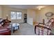 Comfortable living room featuring a cozy armchair, leather sofa, and ample natural light at 14656 W Vassar Dr, Lakewood, CO 80228
