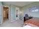 Home office with neutral carpeting, a large desk, and an entry to the hallway at 14656 W Vassar Dr, Lakewood, CO 80228