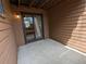 Concrete patio area with wood plank walls and view of the interior through the sliding glass door at 9556 W 89Th Cir, Broomfield, CO 80021