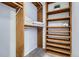 Walk in closet features wooden shelving and hanging rods for ample storage at 1777 Larimer St # 1203, Denver, CO 80202