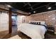 Bedroom features exposed brick, recessed lighting, sliding barn doors, and black ceiling at 1172 Harrison St, Denver, CO 80206