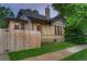 Charming yellow brick home featuring mature trees, a fenced yard, and a classic chimney at 1172 Harrison St, Denver, CO 80206
