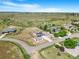 Aerial view of a property and neighboring houses surrounded by large open fields on a sunny day at 497 Valley Way, Bennett, CO 80102