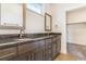 Bathroom featuring a double vanity with dark countertops, modern sinks, and white cabinets at 497 Valley Way, Bennett, CO 80102