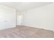 Spacious bedroom featuring plush carpeting, bright white walls, and a door leading to a walk-in closet at 497 Valley Way, Bennett, CO 80102