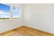 A bright bedroom with hardwood floors and a large window offering natural light and landscape views at 497 Valley Way, Bennett, CO 80102