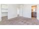 Bright bedroom with neutral carpet and white walls, also featuring a closet and attached bathroom at 497 Valley Way, Bennett, CO 80102