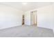Spacious bedroom with neutral carpet, white trim, and a closet for storage at 497 Valley Way, Bennett, CO 80102