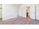 Bright bedroom featuring neutral carpet, white walls, closet, and a door to the attached bathroom at 497 Valley Way, Bennett, CO 80102