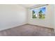 Sunny bedroom with neutral carpet, white walls, and a window offering an outdoor view at 497 Valley Way, Bennett, CO 80102