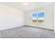 Bright bedroom with neutral carpet and a window offering natural light and landscape views at 497 Valley Way, Bennett, CO 80102