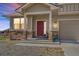 Charming home featuring a red front door, stone accents and an attached garage to the right at 497 Valley Way, Bennett, CO 80102