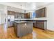 Modern kitchen featuring stainless steel appliances, a large island, and hardwood floors at 497 Valley Way, Bennett, CO 80102