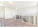 Upstairs loft area with neutral carpet and staircase with black iron railing at 497 Valley Way, Bennett, CO 80102