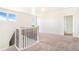 Staircase with carpeted stairs and black iron railing, leading to a bright, open living space at 497 Valley Way, Bennett, CO 80102