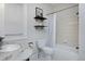 Well-lit bathroom featuring classic tile, shower/tub combo, and floating shelves at 2424 N Clay St, Denver, CO 80211