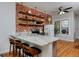 Kitchen featuring a brick wall, open shelving, marble countertop island, and hardwood floors at 2424 N Clay St, Denver, CO 80211