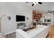 Open-concept living room flows to kitchen, featuring a brick accent wall and hardwood floors at 2424 N Clay St, Denver, CO 80211