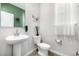 Bright powder room features pedestal sink, toilet, and decorative accents at 23652 E 40Th Ave, Aurora, CO 80019