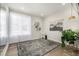 Sunlit flex space with light walls, bright window, decorative shelving, and an area rug on hardwood floors at 23652 E 40Th Ave, Aurora, CO 80019