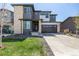Modern two-story home with stone accents, gray siding, well maintained lawn, and a two car garage on a sunny day at 23652 E 40Th Ave, Aurora, CO 80019