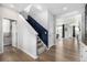 Hallway features natural lighting and light wood floors adjacent to a staircase with navy banister at 23652 E 40Th Ave, Aurora, CO 80019