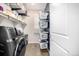 Efficient laundry room equipped with a washer, dryer, shelving, and hanging laundry baskets for organization at 23652 E 40Th Ave, Aurora, CO 80019