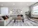 Bright living room featuring a comfortable sectional sofa, stylish art, and ample natural light from the windows at 23652 E 40Th Ave, Aurora, CO 80019