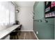Bright office space featuring a built-in desk, green accent wall with hooks, and natural light at 23652 E 40Th Ave, Aurora, CO 80019