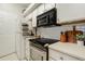 Well-equipped kitchen featuring white cabinets, a modern cooktop, and stainless steel oven, providing a delightful cooking experience at 6021 W Castlegate Dr # E18, Castle Rock, CO 80108