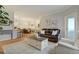 Open-concept living room featuring hardwood floors, a leather sofa, and natural light at 6021 W Castlegate Dr # E18, Castle Rock, CO 80108
