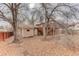 View of the backyard with a wooden deck, covered patio, storage shed and mature trees at 909 E 7Th Ave, Broomfield, CO 80020