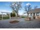 Spacious outdoor patio area featuring a built-in grill, countertop, stone accents, pergola and mature trees at 6231 Prospect Rd, Longmont, CO 80503