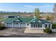 Aerial view of horse barn featuring multi-car garage, modern aesthetic, and metal roof at 6231 Prospect Rd, Longmont, CO 80503