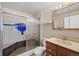 Bathroom featuring a shower with decorative blue tiles, a toilet, and a vanity at 6231 Prospect Rd, Longmont, CO 80503