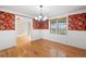 Dining room with hardwood floors, red floral wallpaper and view of the yard at 6231 Prospect Rd, Longmont, CO 80503