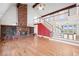 Inviting living room with vaulted ceilings, a grand brick fireplace, hardwood floors, and a staircase to the upper level at 6231 Prospect Rd, Longmont, CO 80503