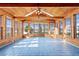 Cozy sunroom with wood paneled walls, ceiling, tiled flooring, and large windows offering plenty of natural light at 6231 Prospect Rd, Longmont, CO 80503