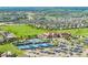 Aerial view of a community clubhouse with a pool, tennis courts, and ample parking, showcasing community amenities at 27375 E Alder Dr, Aurora, CO 80016