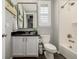 A clean bathroom featuring a vanity with a black countertop, and a shower and tub combo at 27375 E Alder Dr, Aurora, CO 80016