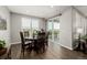 Bright dining area features a wood table, six chairs, wood floors, and access to a covered patio at 27375 E Alder Dr, Aurora, CO 80016