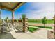 Quaint front porch showcasing stone pillars, a white rocking chair, and a view of the serene surroundings at 27375 E Alder Dr, Aurora, CO 80016