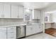 Modern kitchen featuring white cabinets, stainless steel appliances, tile backsplash, and quartz countertops at 1665 Yukon St, Lakewood, CO 80214