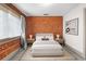 Bright bedroom with brick wall accent, neutral carpet, and modern night stands at 3211 Zuni St # 14, Denver, CO 80211