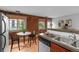 Modern kitchen and dining area with brick wall, stainless steel appliances, and natural light at 3211 Zuni St # 14, Denver, CO 80211