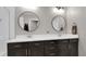 Bright bathroom featuring a double sink vanity with quartz countertop, modern lighting, and round mirrors at 7888 Tejon St, Denver, CO 80221