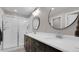 Bathroom showcasing double vanity sinks, modern light fixtures, and a glass-enclosed shower at 7888 Tejon St, Denver, CO 80221