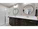 Bright bathroom featuring a double sink vanity, modern lighting, and a glass-enclosed shower at 7888 Tejon St, Denver, CO 80221