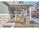 Inviting covered porch with charming decor including flowers, wagon wheels, and a decorative fountain at 7888 Tejon St, Denver, CO 80221