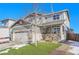 Charming two-story home with well-manicured lawn, porch decorations, an American flag, and a two-car garage at 7888 Tejon St, Denver, CO 80221